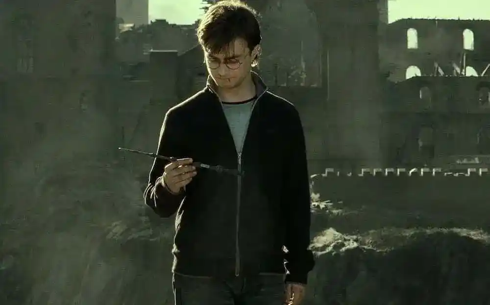 Harry Potter holding the elder wand outside a war-torn Hogwarts