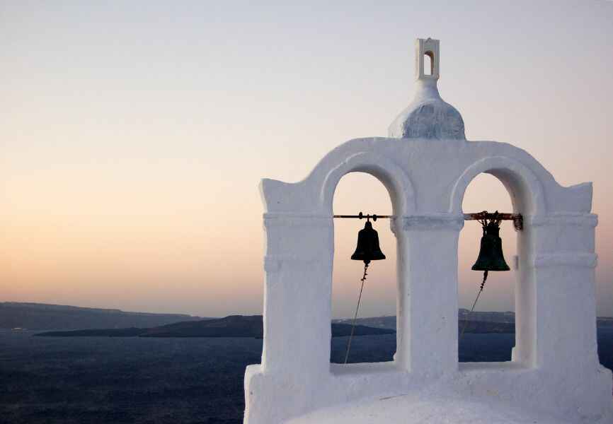 Two bronze bells in a white bell tower