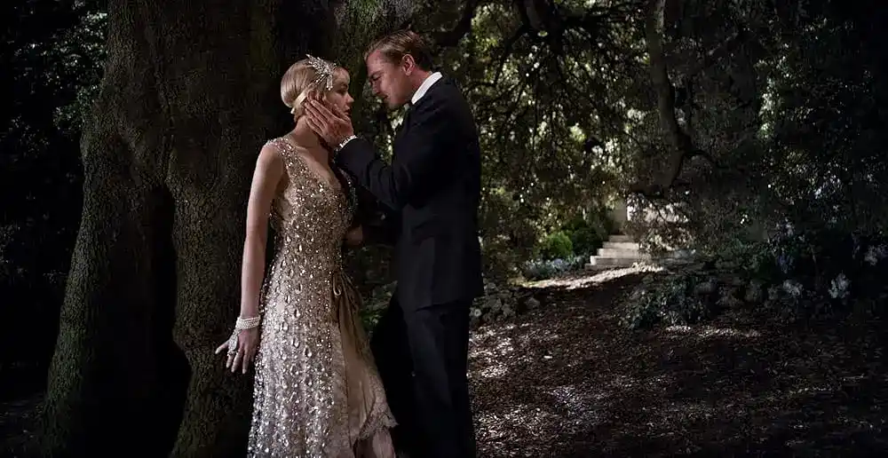 Gatsby and Daisy about to kiss behind a tree
