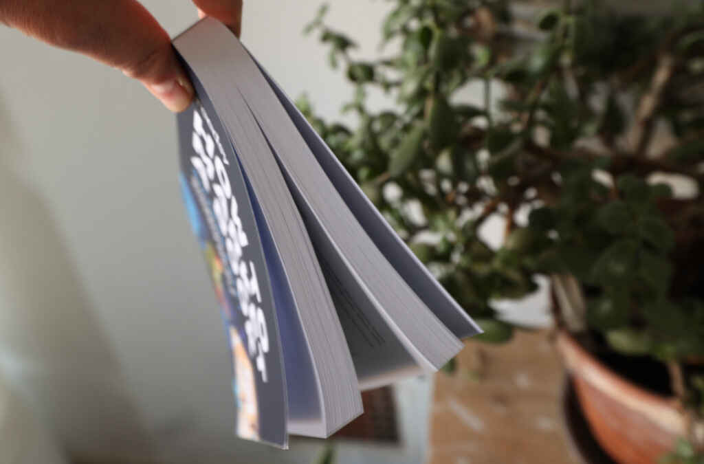 Holding a KDP Print book copy to show the split in the book's middle
