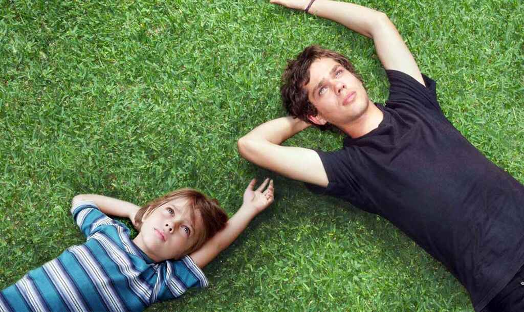 Screengrab from Boyhood, same character as a kid and teenager laying together on the grass