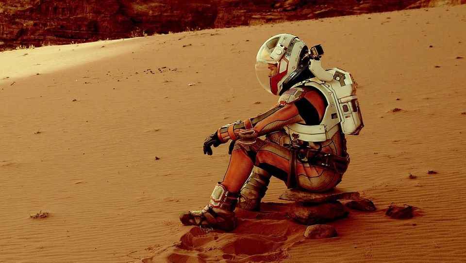 conflict | A still image from the film, The Martian, with Matt Damon sitting on the surface of Mars
