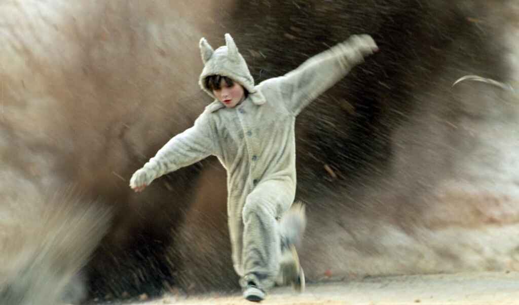 Still from the movie Where The Wild Things Are with the protagonist running wild in his jump suit